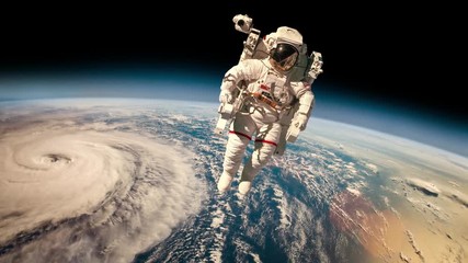 Wall Mural - astronaut in outer space against the backdrop of the planet earth. typhoon over planet earth. elemen