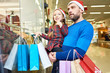 © Seventyfour - Man carrying little girl while exploring window shop in mall buying Christmas presents together