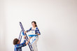© satura_ - Teamwork, renovation and repair concept - Portrait of funny couple doing redecoration in apartment with copy space