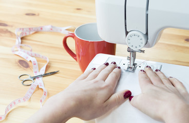 Close up of young woman working on a sewing machine