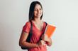 © kleberpicui - Portrait of a cheerful smiling african student girl wearing backpack and holding books isolated over white background