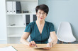 © satura_ - Business, technology and people concept - middle aged woman sit at the table and use a tablet