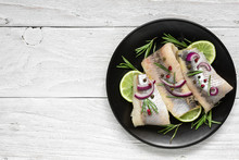 Herring Fillet With Pepper, Rosemary, Onion And Lime On Black Plate On White Background. Top View With Copy Space