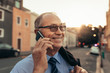 © Jacob Lund - Senior businessman on city street using phone