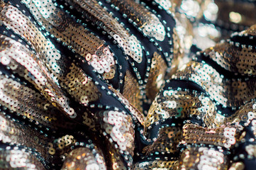  Background sparkle. Holiday abstract glitter background with flashing lights. Fabric sequins in gold tones ..