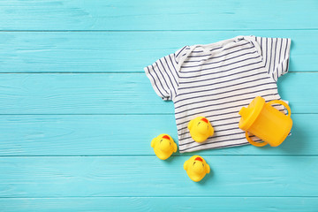 Flat lay composition with baby clothes and accessories on wooden background. Space for text