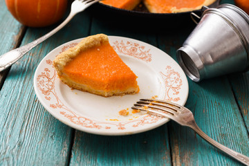 Wall Mural - Homemade pumpkin dessert. Piece of traditional open pumpkin pie being eaten