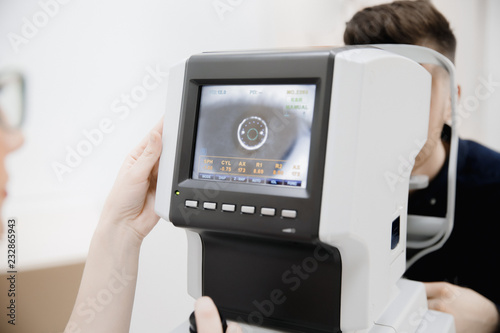 Cuadros en Lienzo Female hand doctor holds monitor of ophthalmological device with indicators eye