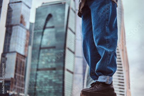 Foto Legs of trendy dressed hipster girl in front of skyscrapers in Moskow city