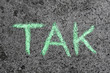 Słowo TAK napisane zieloną kredą na betonie. Dziecięcy napis