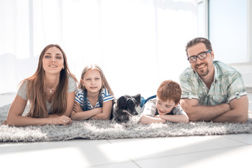 Wall Mural - Happy family lying on carpet in room at new home