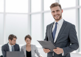 Wall Mural - smiling businessman with a clipboard on the background of the of