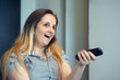 © polack - Woman with tv remote control on sofa at home.
