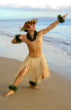 Male Hula Dancer Performing On The Sand Next To The Ocean.