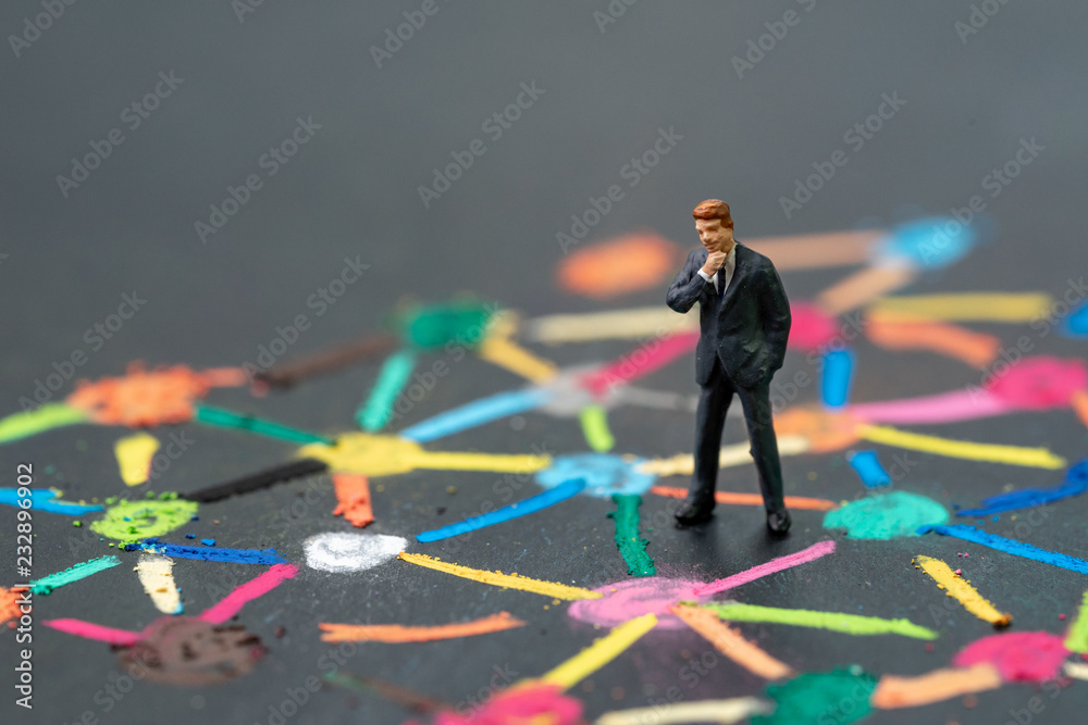 Anti social man, business connection or social network concept, miniature people businessman standing on colorful pastel chalk line link and connect between multiple dot or tiers on blackboard