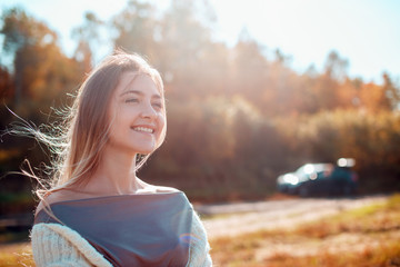 Wall Mural - Pretty girl posing on camera and enjoying sunny autumn day.