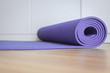 Rolling or folding purple color yoga mat after a workout,Exercise equipment