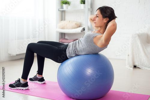 Fotografia Fitness young woman doing abdominal crunches on fit ball.