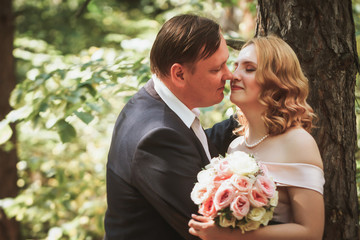 bride and groom kiss on the background of trees and forest