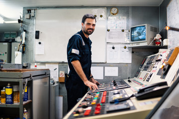 Marine engineer officer in engine control room ECR. Seamen's work. He starts or stops main engine of ship