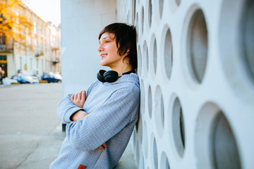 Outdoor portrait of handsome teen sweden boy by over white urban wall background.