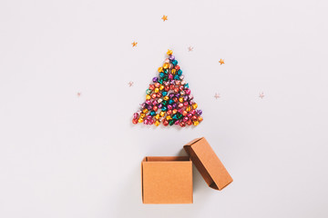 top view of colorful bell are christmas tree and gift box on blue background. christmas concept.