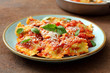 Pasta Italiana ravioli ripieni con salsa di pomodoro e parmigiano su tavolo di cucina,