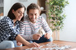© Pixel-Shot - Young couple doing jigsaw puzzle at home