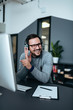 © bnenin - Happy businessman working with headset at modern office.