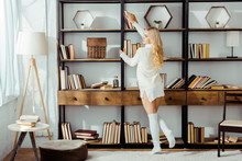 Beautiful Adult Woman Taking Book From Wooden Rack