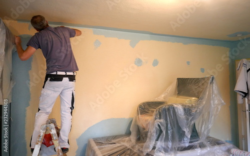 Fotomural Rear view of a painter stroking a wall with a paint roller