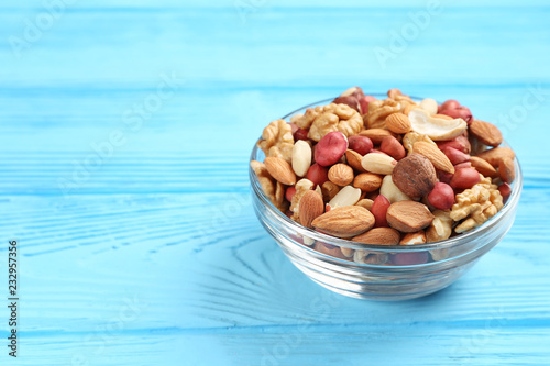 Fotografía bowl with different mixed nuts on a blue table