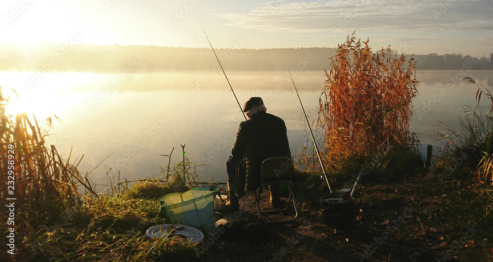 Amatorski wędkarz łowi na jesieni w jeziorze - obrazy, fototapety, plakaty 