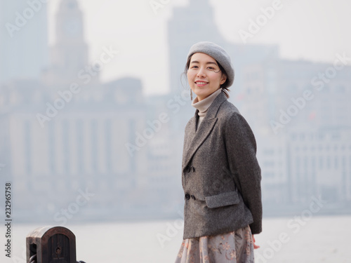 Fotografia Beautiful young brunette woman in gray coat dress looking and smiling at you