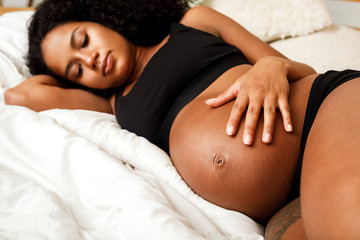 Wall Mural - Close up of pregnant woman touching her belly 