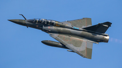 Wall Mural - French military green double seater fighter jet aircraft in flight with a blue sky