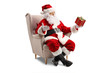 © Ljupco Smokovski - Santa Claus sitting in an armchair and holding a present