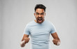 emotion, anger and people concept - angry indian man screaming over grey background