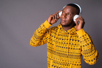 Young handsome African man with short hair against gray backgrou