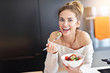 © Kalim - Beautiful Smiling Woman Eating Fresh Organic Vegetarian Salad In Modern Kitchen