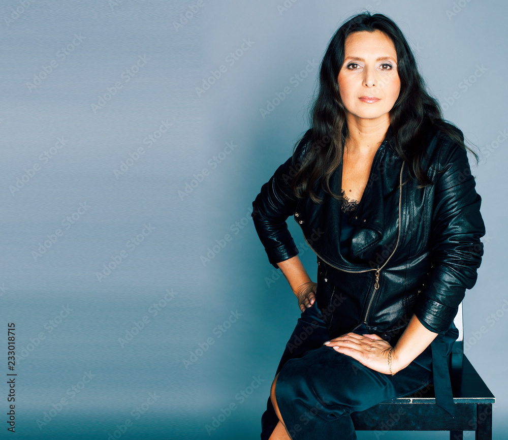 pretty brunette confident mature woman sitting on chair in studi Stock ...