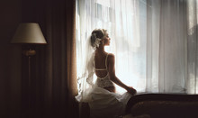 Beautiful Bride In Sexy Lingerie Standing At The Window In The Room. Morning Preparation For The Wedding.