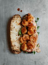 Shrimp Po Boy With New Orleans Style Barbecue Sauce On A Toasted French Baguette With Lettuce, Tomato And Remoulade