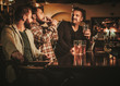 © Nejron Photo - Old friends having fun and drinking draft beer at bar counter in pub.