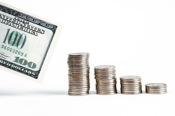 The concept of accumulation of cash savings. A stack of coins with a hundred dollar bill.