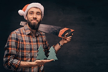 Christmas concept. Worker, carpenter, handyman is posing with a saw.