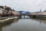 Fototapeta Na drzwi - panoramic winter view of the historic center of Salzburg Austria surrounded by the Alps covered with snow in a foggy haze from the bridge with padlocks