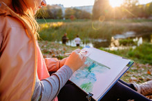 Teenager School Girl Drawing Beautiful Picture Outdoor In The Park At Sunset. Open Air Activity For School Age Children Concept. Close Up