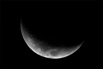 Close up of waxing crescent Moon with craters details, at 1500 mm of focal length, taken with telescope with dark background.