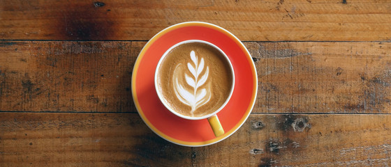 a cup of latte art coffee on wooden background